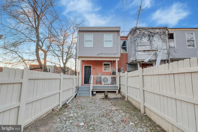 a view of a house with a small yard and wooden fence
