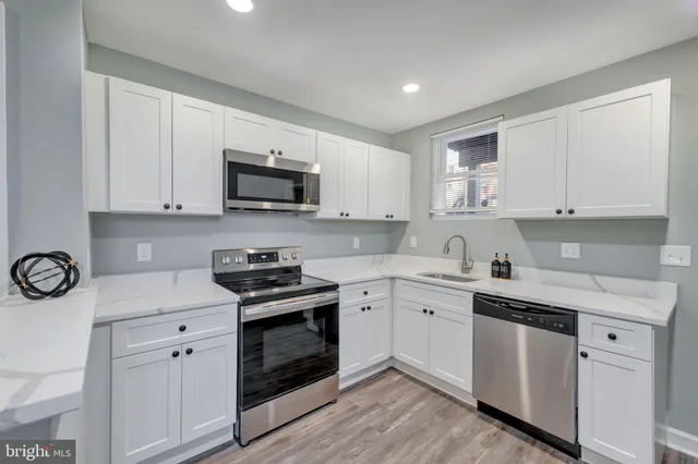 a kitchen with cabinets stainless steel appliances and a sink