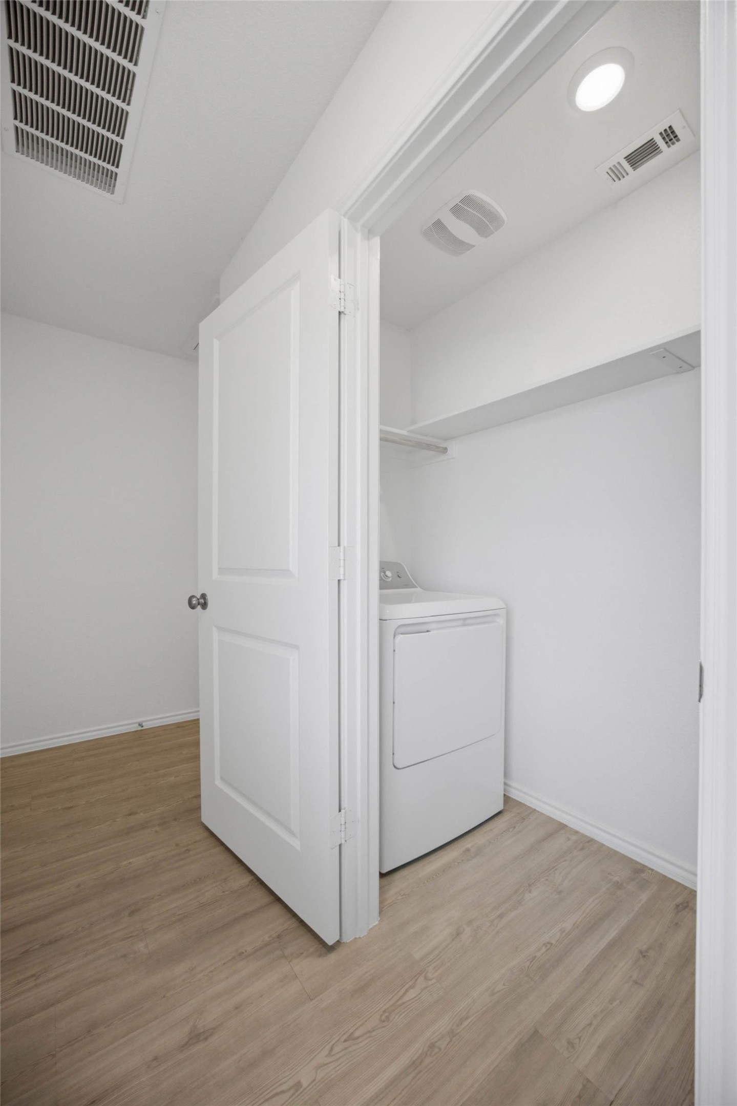 171 Cattle Queen Road Jarrell, TX 76537 - Photo 15 of 38 A dedicated laundry closet features vinyl flooring and built-in shelving above the utility hookups.