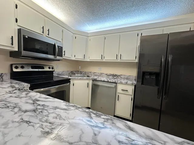 a kitchen with a refrigerator stove and microwave