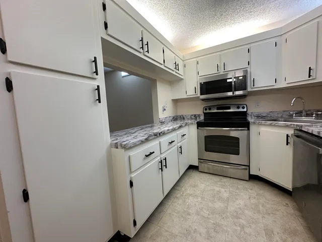 a kitchen with stainless steel appliances white cabinets and a stove