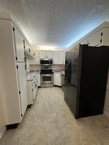 a kitchen with stainless steel appliances a refrigerator and cabinets
