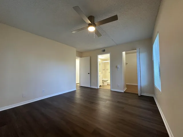 an empty room with wooden floor and natural light
