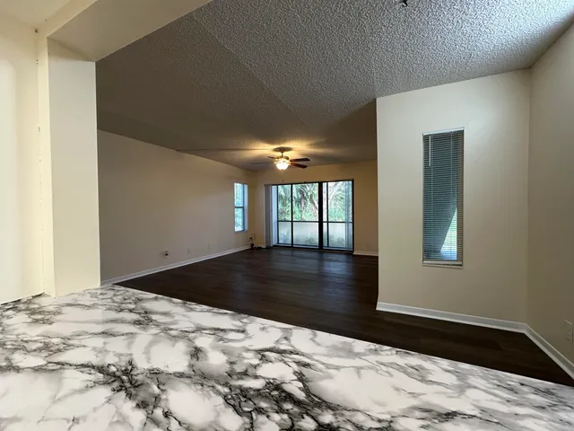 a view of a bedroom with wooden floor and window