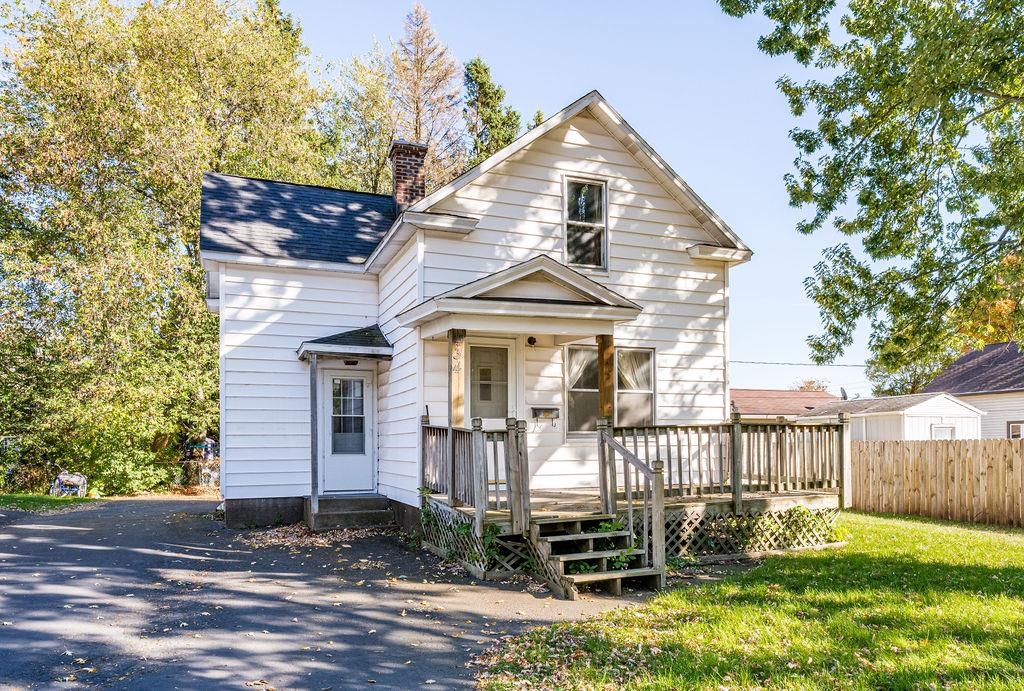 View of front of home featuring a chimney and a deck