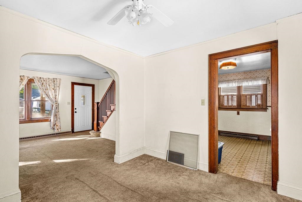 434 12th Street Cloquet, MN 55720 - Photo 6 of 22 Spare room featuring carpet, stairs, arched walkways, ornamental molding, and a ceiling fan