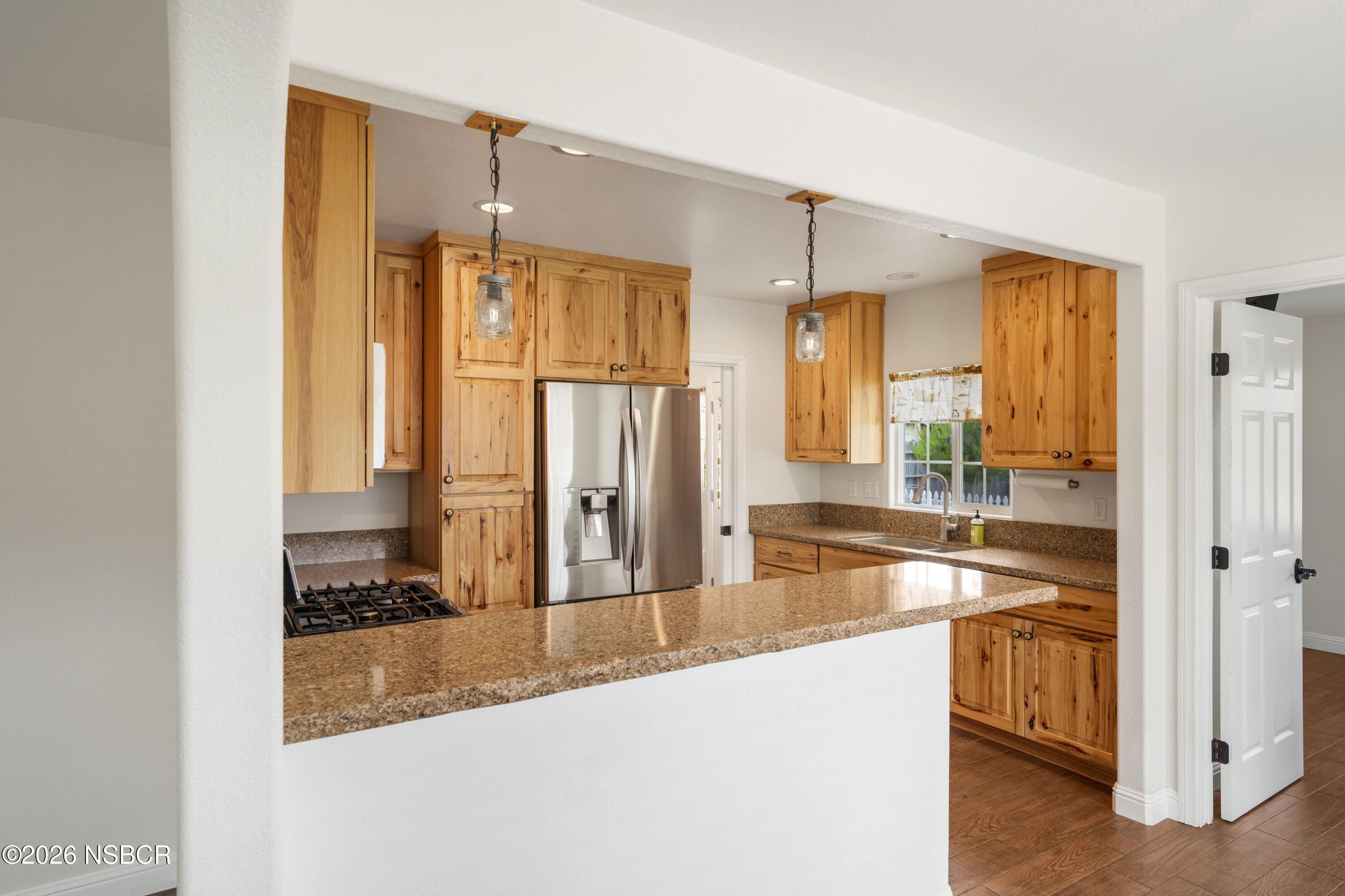 138 North E Street Lompoc, CA 93436 - Photo 12 of 35 a large kitchen with kitchen island a large window a sink and cabinets