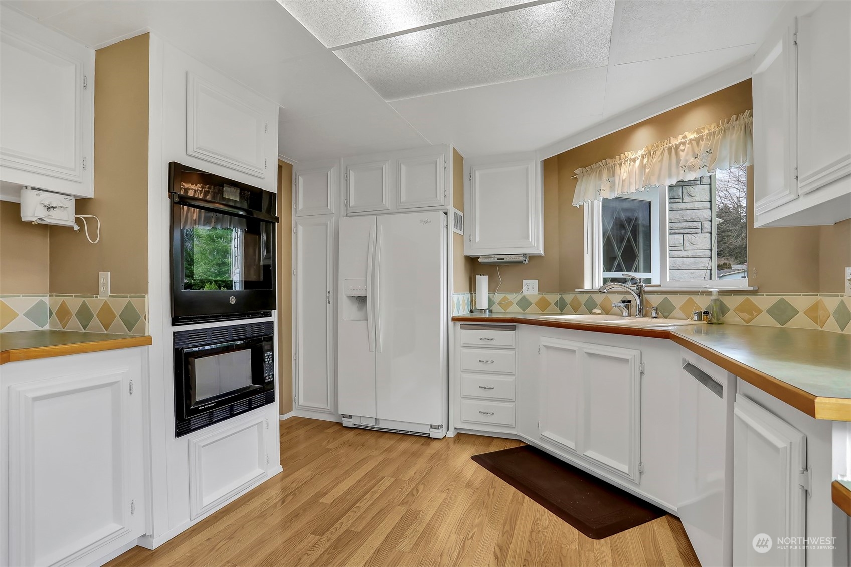 23921 Lake Drive West Bothell, WA 98021 - Photo 15 of 40 a kitchen with granite countertop white cabinets and white appliances
