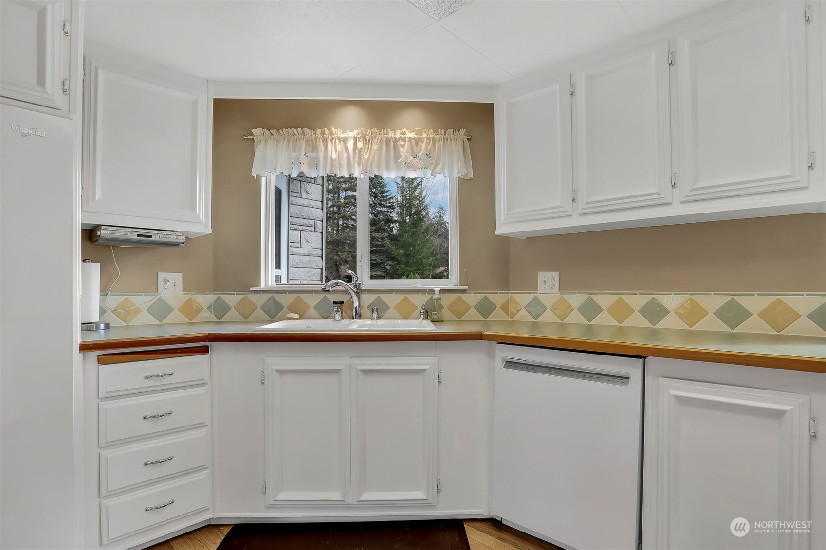 23921 Lake Drive West Bothell, WA 98021 - Photo 17 of 40 a kitchen with granite countertop white cabinets and a window