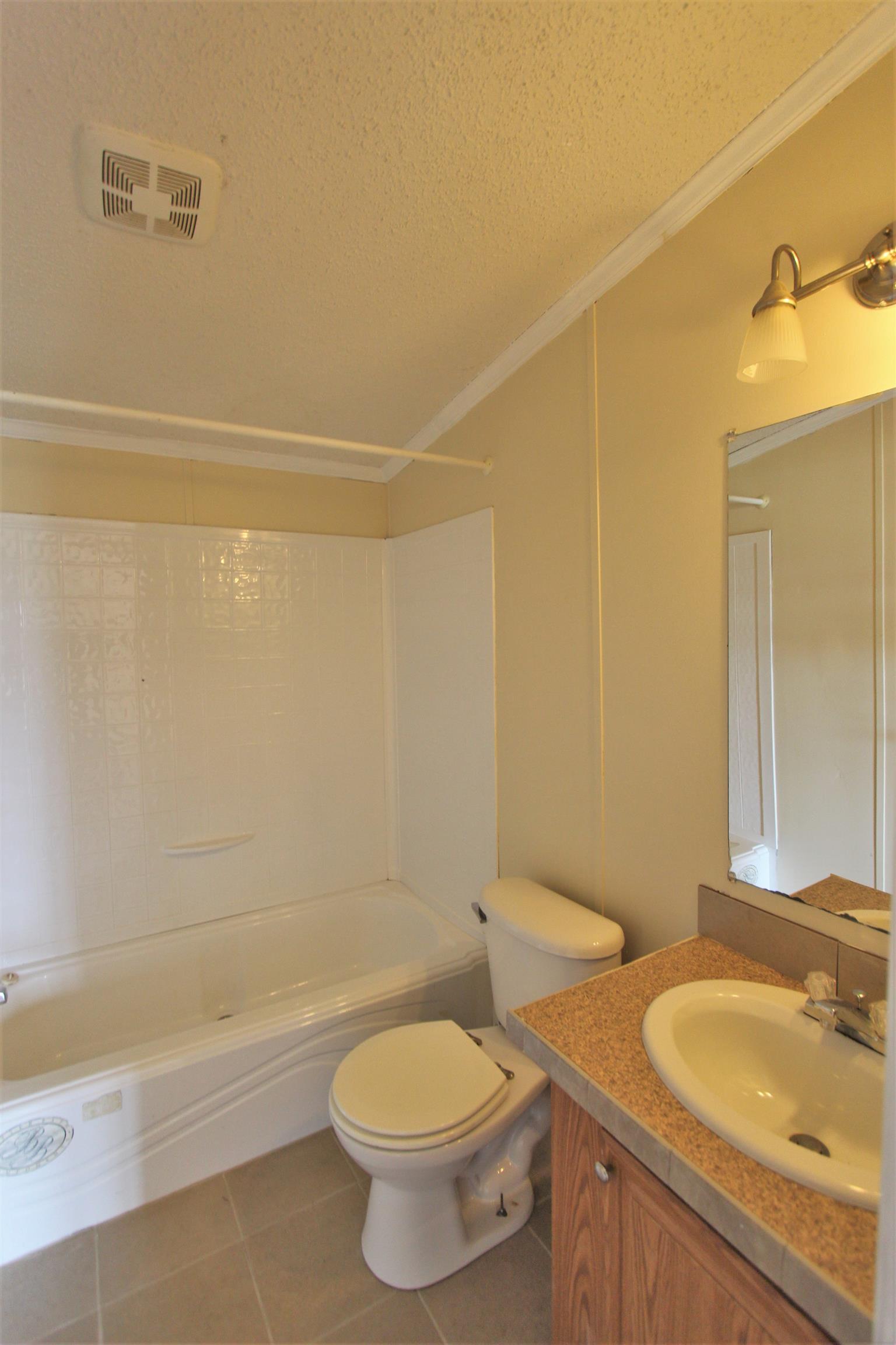 4430 Beasleys Bend Road Lebanon, TN 37087 - Photo 15 of 16 a bathroom with a granite countertop toilet a sink and bathtub