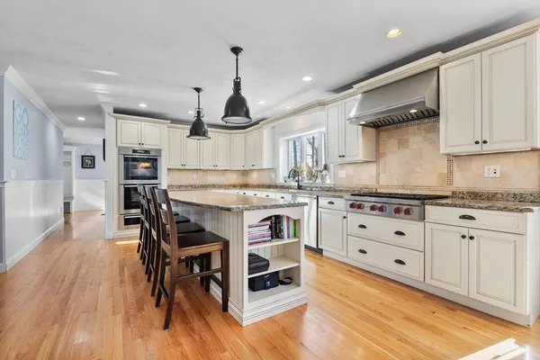 a kitchen with granite countertop a white stove top oven cabinets and wooden floor