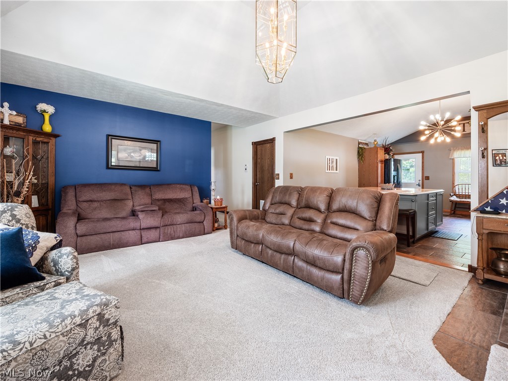 5245 Center Road Philo, OH 43771 - Photo 13 of 39 Living room with a notable chandelier, lofted ceiling, and carpet