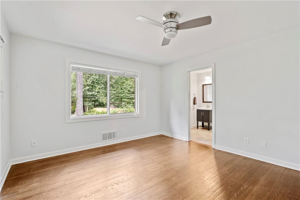 3363 Briarcliff Road Northeast Atlanta, GA 30345 - Photo 33 of 44 an empty room with wooden floor chandelier fan and windows