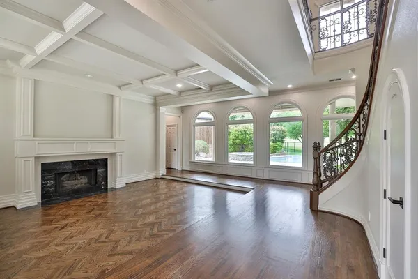 wooden floor fireplace and windows in an empty room