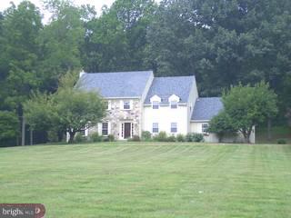 a view of a house with a big yard and large trees