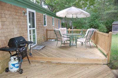 28 Deer Ridge Road Mashpee, MA 02649 - Photo 10 of 13 a view of a patio with a table and chairs under an umbrella