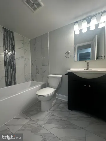 a bathroom with a toilet a sink and bathtub