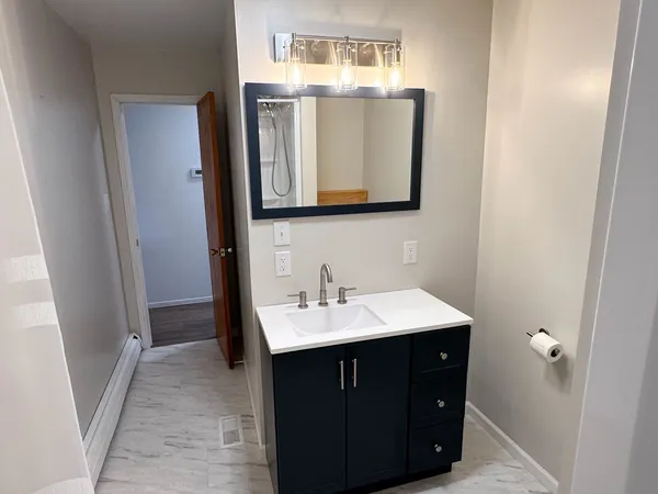 a bathroom with a sink vanity and a mirror