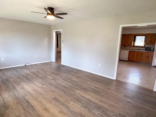 a view of a room with wooden floor and ceiling fan