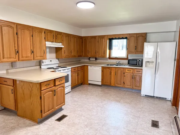 a kitchen with stainless steel appliances granite countertop a stove a sink dishwasher and a refrigerator