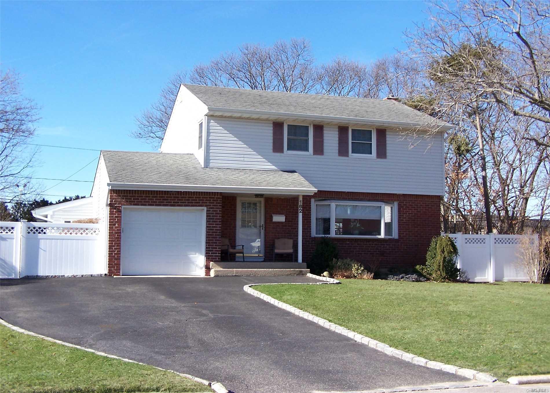 162 Tree Road Centereach, NY 11720 - Photo 1 of 1 a front view of a house with a garden and yard