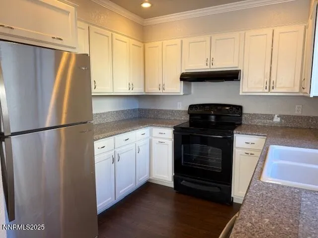 a kitchen with stainless steel appliances white cabinets and a refrigerator