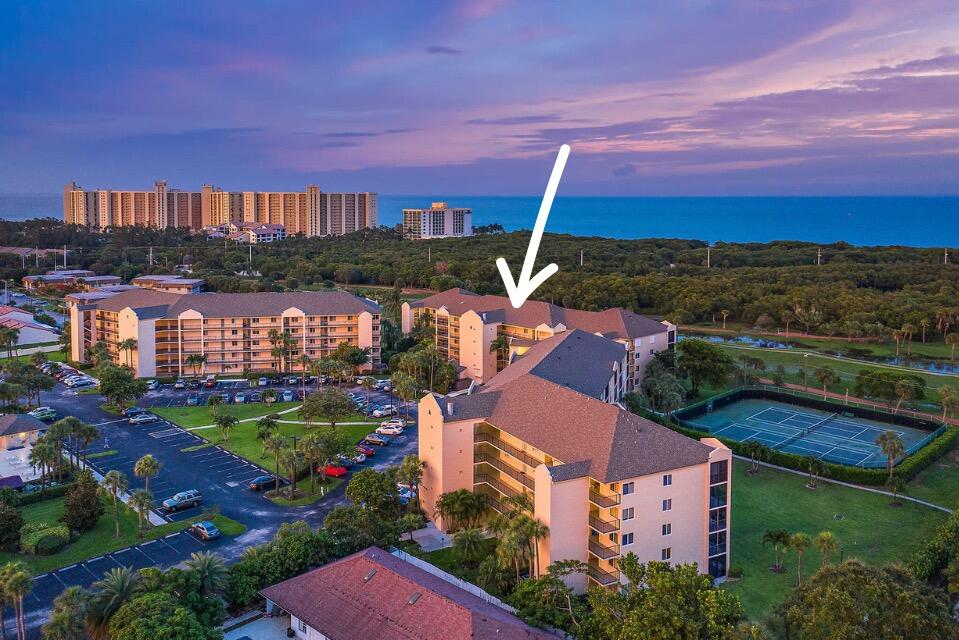 an aerial view of a house with a garden and lake view