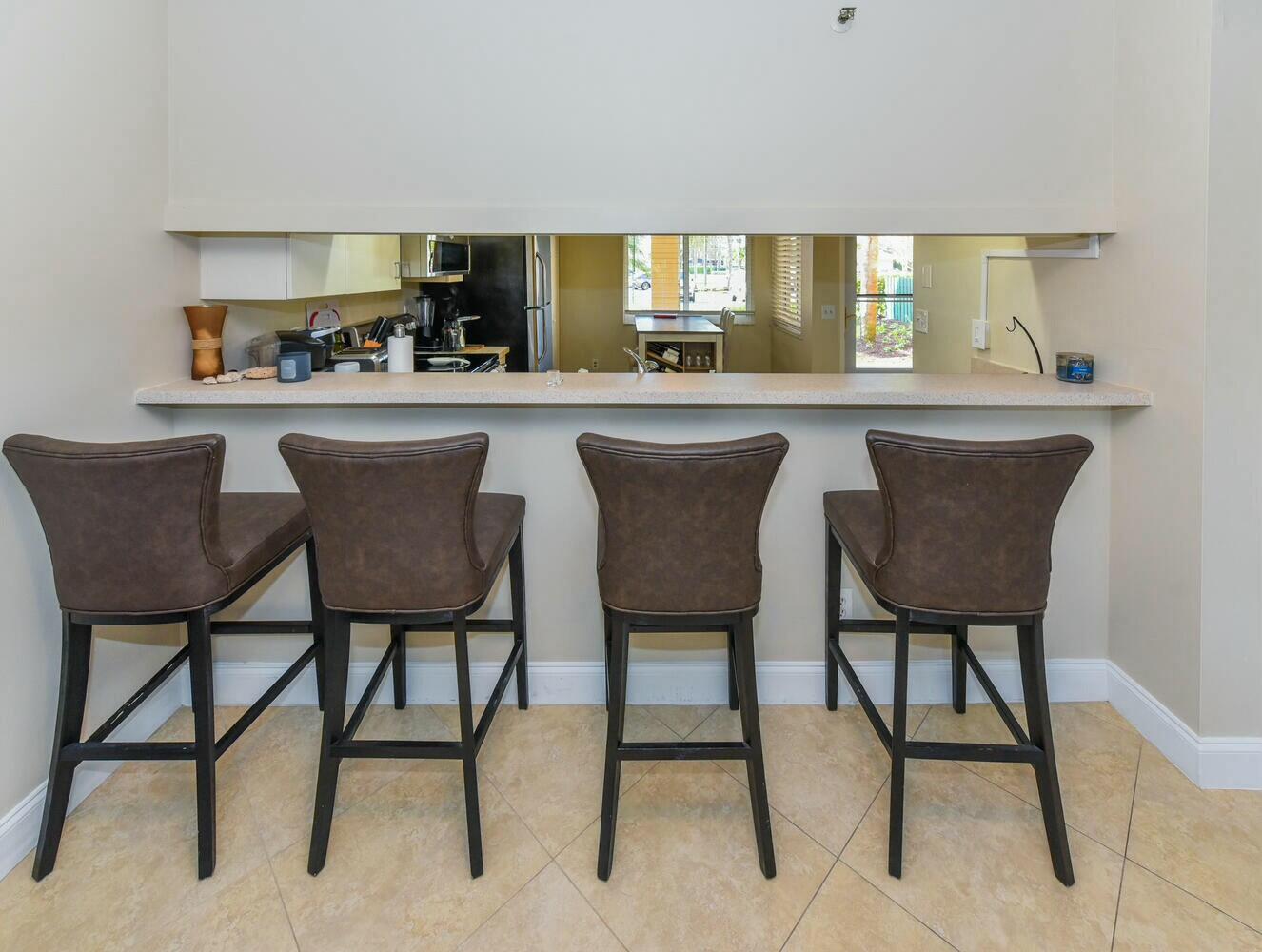 275 Palm Avenue, Unit B106 Jupiter, FL 33477 - Photo 11 of 43 a kitchen with a dining table chairs and window