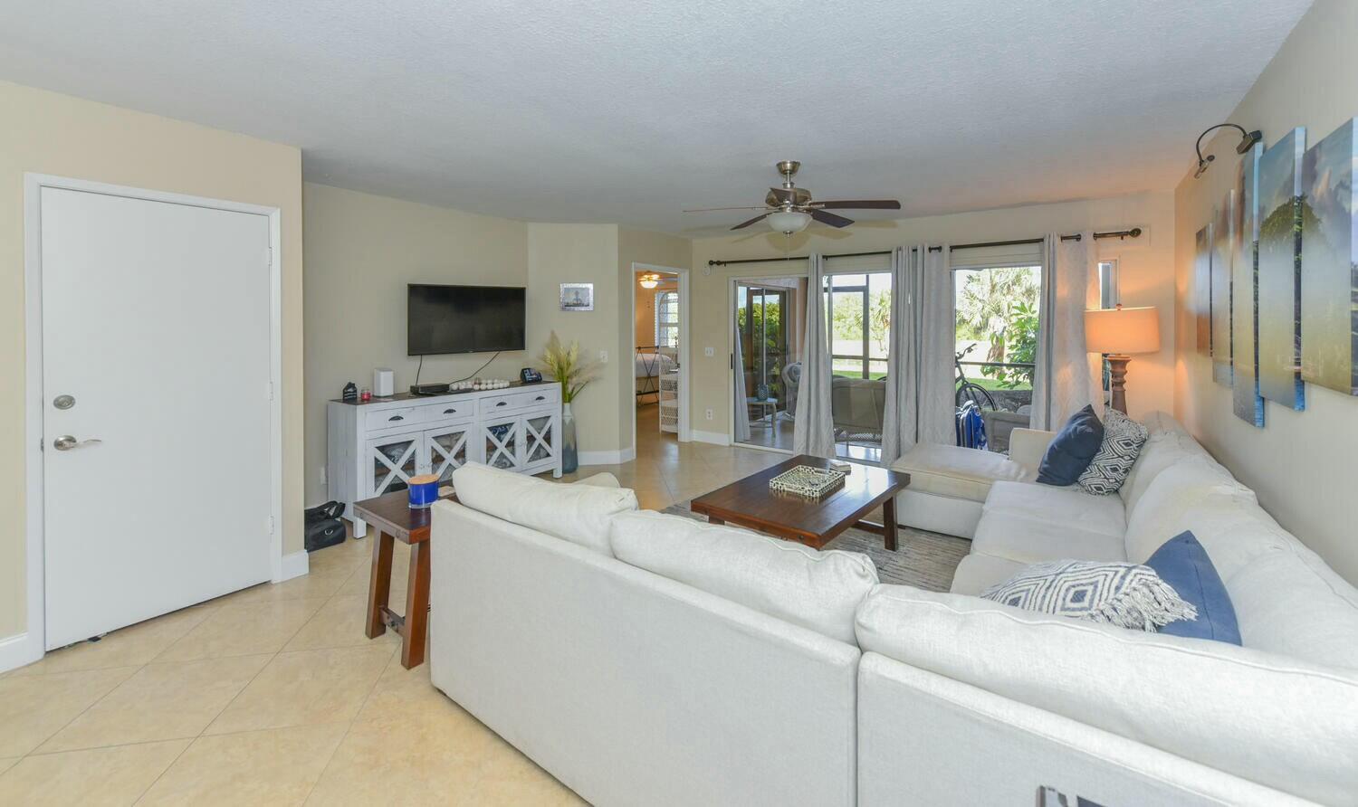 275 Palm Avenue, Unit B106 Jupiter, FL 33477 - Photo 13 of 43 a living room with furniture and a flat screen tv