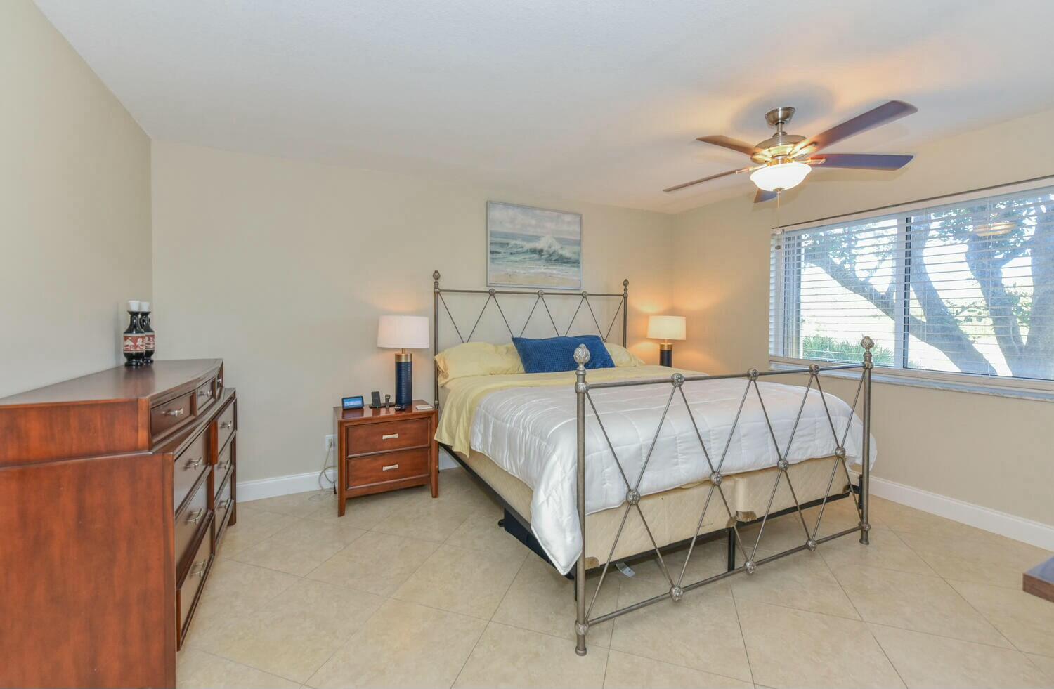 275 Palm Avenue, Unit B106 Jupiter, FL 33477 - Photo 15 of 43 a bed sitting in a bedroom next to a window