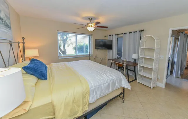 a spacious bedroom with a bed and a flat screen tv