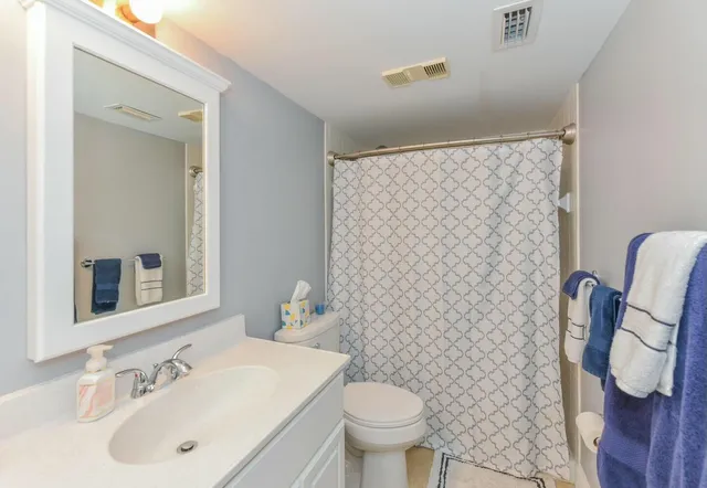 a bathroom with a sink a toilet and shower curtain
