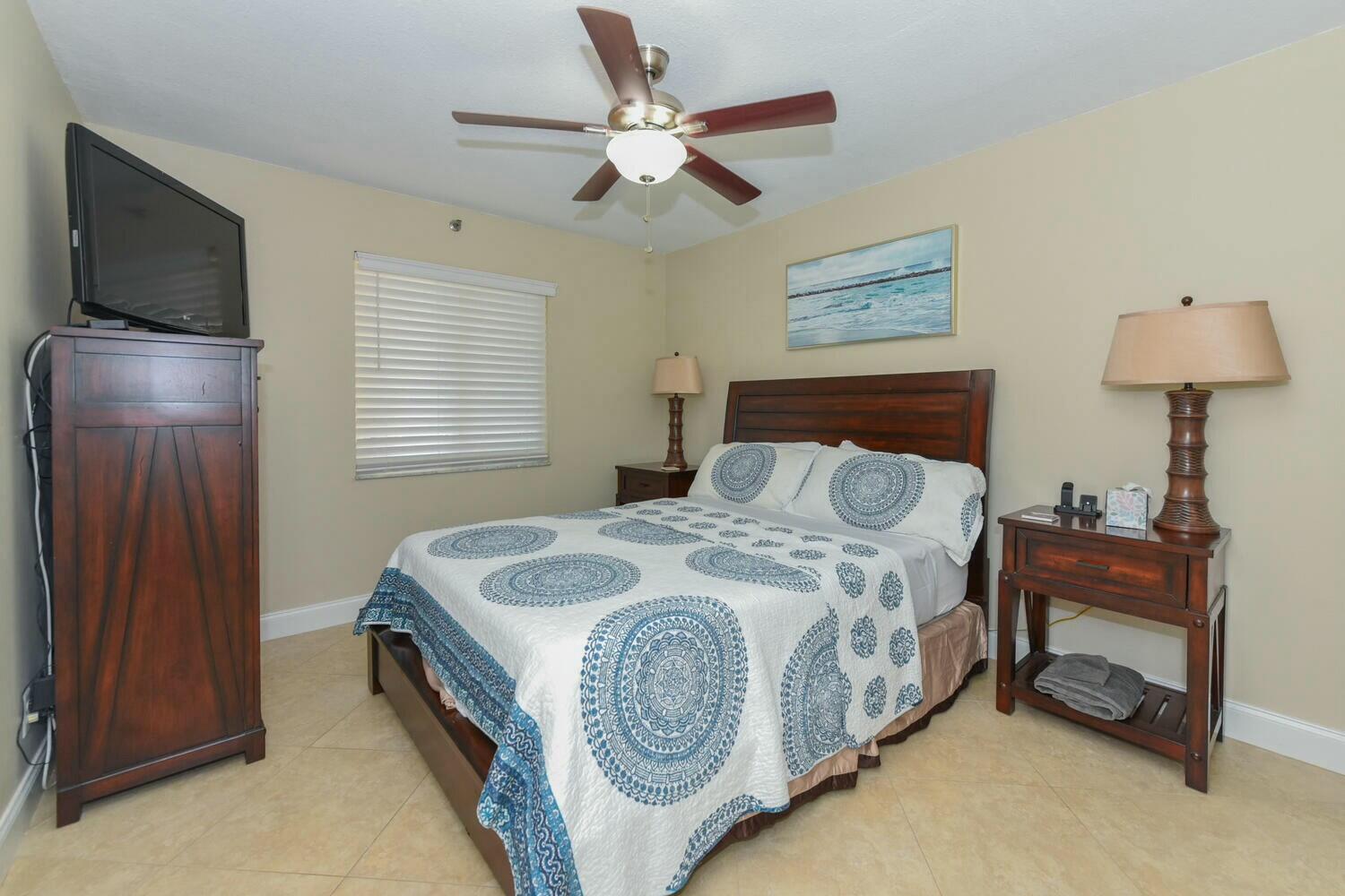 275 Palm Avenue, Unit B106 Jupiter, FL 33477 - Photo 19 of 43 a bedroom with a bed and a chandelier