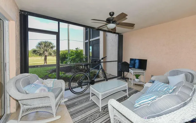a living room with furniture a floor to ceiling window and a flat screen tv