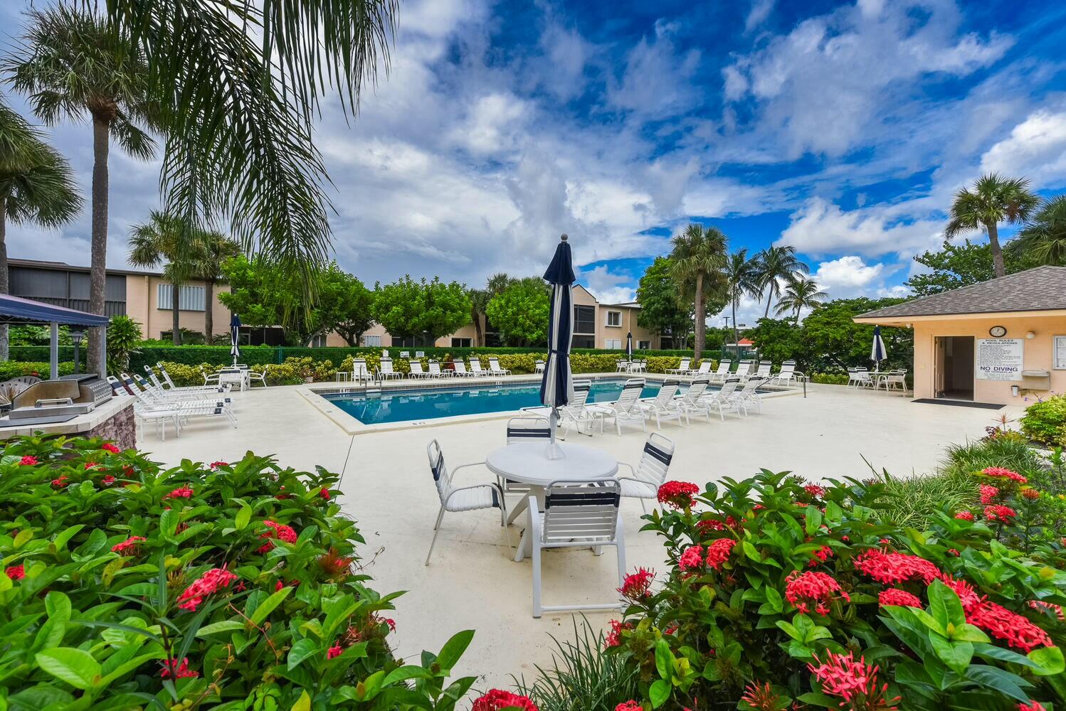 275 Palm Avenue, Unit B106 Jupiter, FL 33477 - Photo 37 of 43 a view of a patio with table and chairs and potted plants