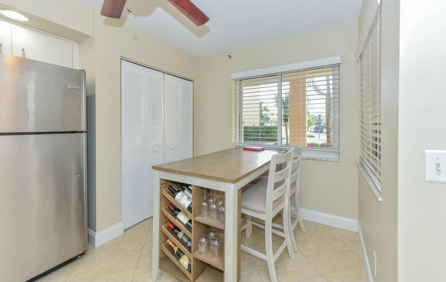 275 Palm Avenue, Unit B106 Jupiter, FL 33477 - Photo 7 of 43 a kitchen with a refrigerator and a table