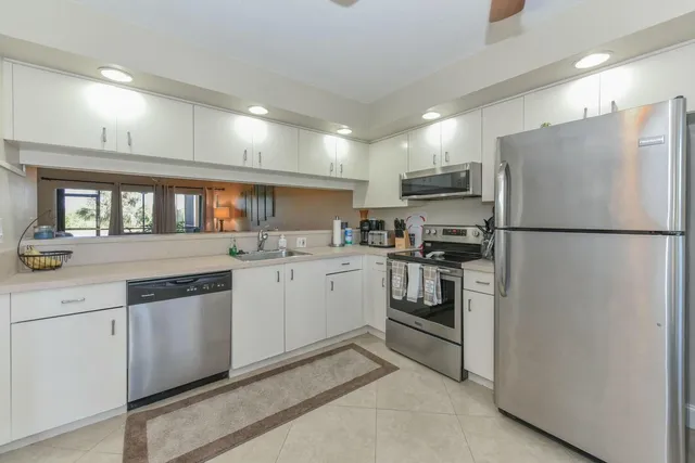 a kitchen with white cabinets and white appliances