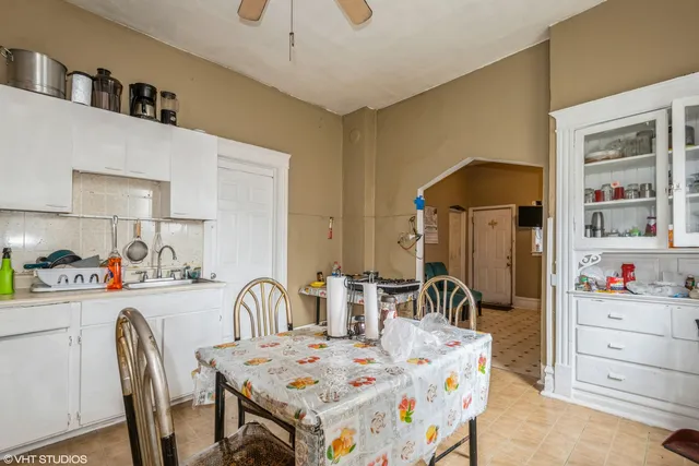 a dining room with furniture a chandelier and a flat screen tv
