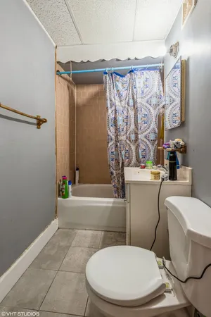 a white toilet sitting next to a bathroom sink and a bathtub