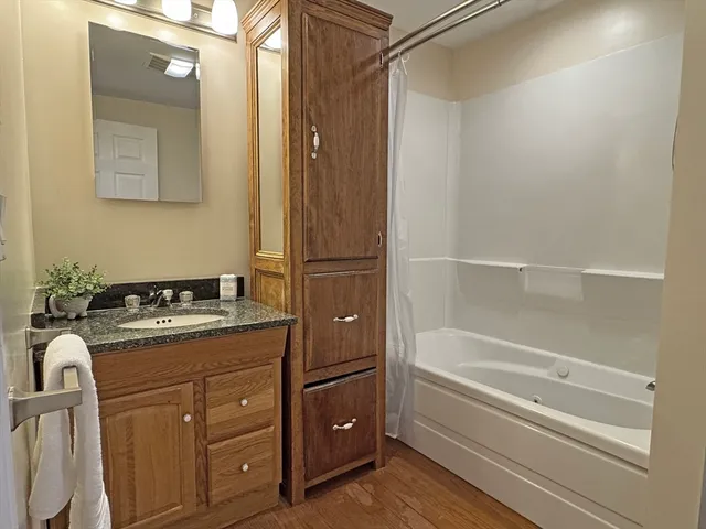 a bathroom with a granite countertop sink toilet and shower