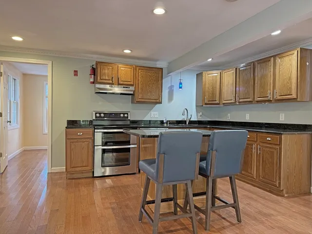 a kitchen with stainless steel appliances granite countertop a stove a sink and a microwave