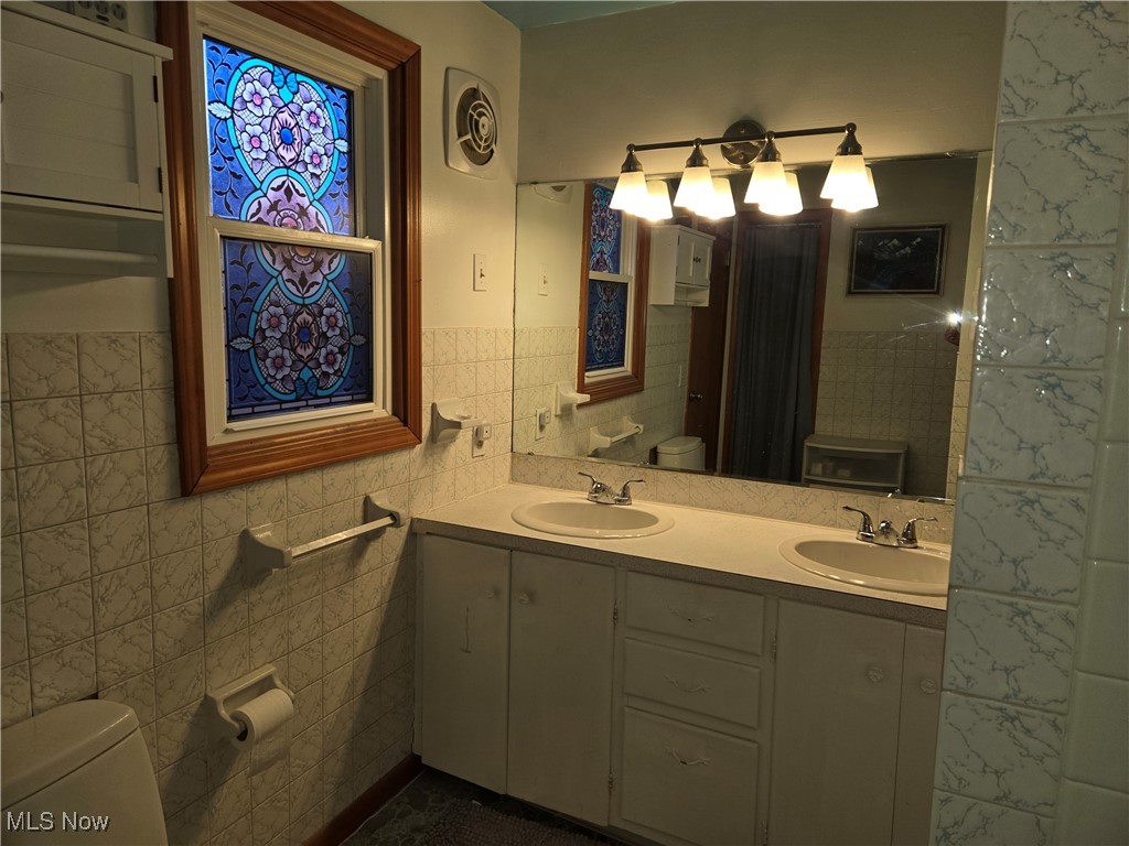 1962 Zenobia Road Norwalk, OH 44857 - Photo 18 of 30 Bathroom featuring vanity, tile walls, and toilet
