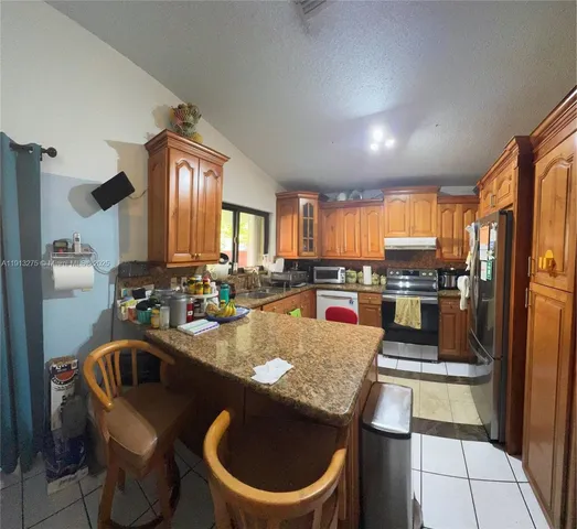 a kitchen with a table chairs sink and refrigerator