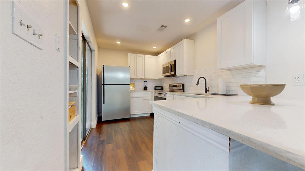 903 Turtle Lake Boulevard, Unit 268 Irving, TX 75060 - Photo 8 of 21 a kitchen with kitchen island a sink stainless steel appliances and cabinets