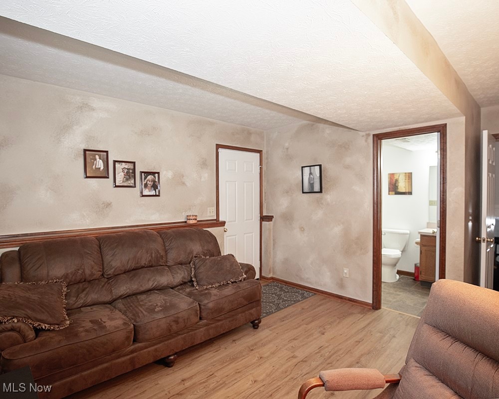 1614 South Abbe Road Elyria, OH 44035 - Photo 29 of 35 Living room with baseboards, a textured ceiling, and light wood finished floors