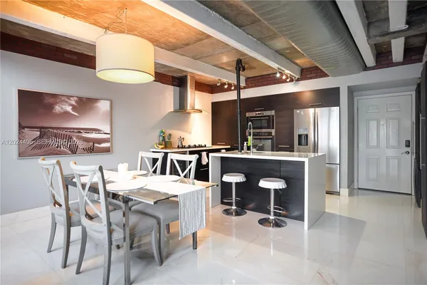 a room with stainless steel appliances kitchen island granite countertop furniture and a view of kitchen