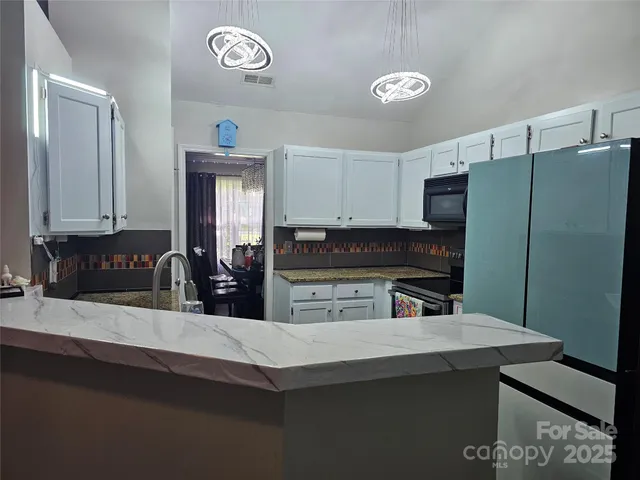 a kitchen with a refrigerator and a stove top oven