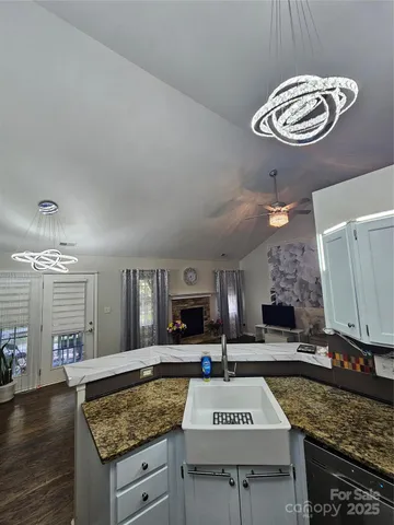a kitchen with stainless steel appliances granite countertop a granite counter tops and a view of living room