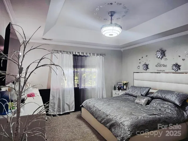 a bed sitting in a spacious bedroom next to a window