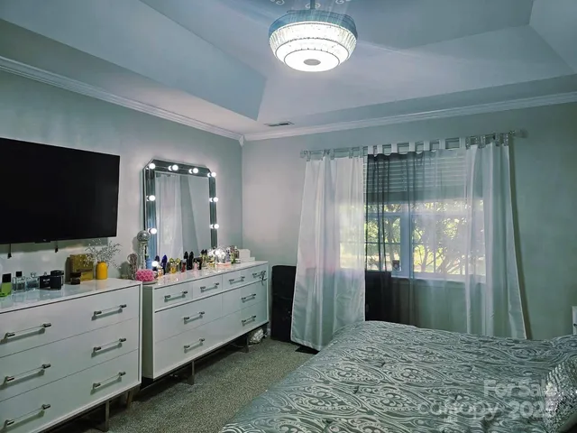 a spacious bedroom with a bed and a flat screen tv